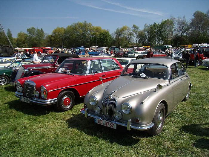 A red Mercedes W108 SClass and an old Jaguar SType sedan Corvettes